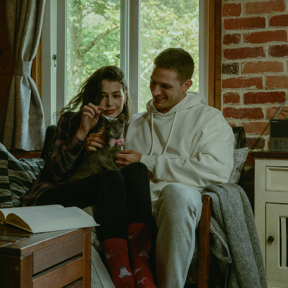 2 people with a cat in the living room