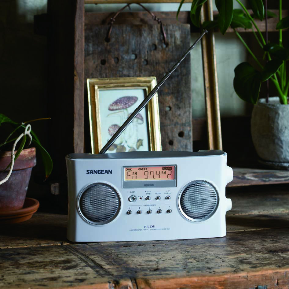 A SANGEAN PR-D5 is placed in front of a picture frame